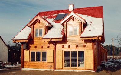 Dom z bali zimą z czerwoną dachówką zbudowany w Niemczech